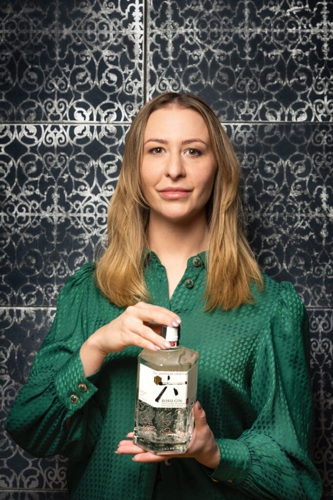 Spirituosen-Expertin Polly Scholz mit Gin-Flasche